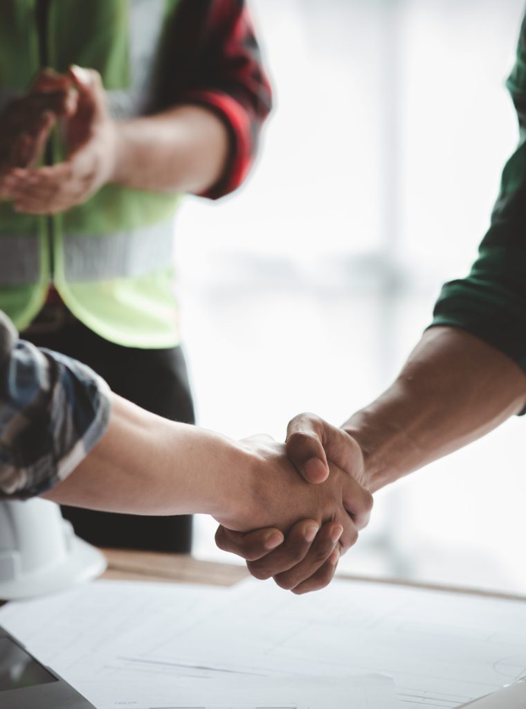 Team engineers and architects shake hands with the condo project owners after the meeting to present room plans and details of the condo building structure. Concept of building design and construction